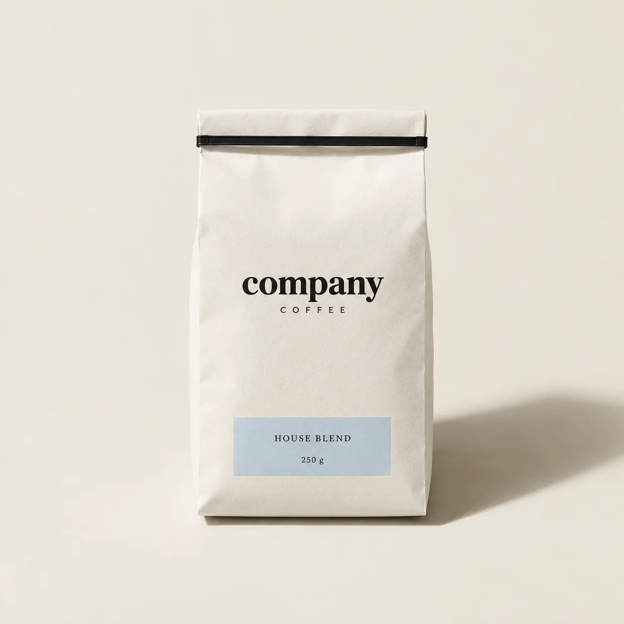 Minimal warm-white Company Coffee bean packaging with a restrained powder-blue label