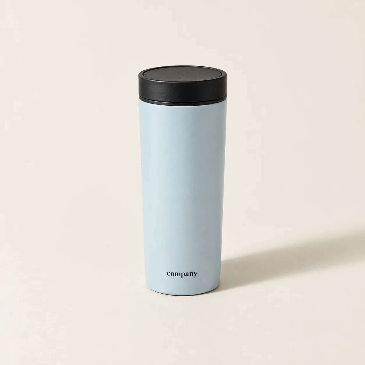 Powder-blue Company Coffee travel tumbler with a black lid on a warm neutral background